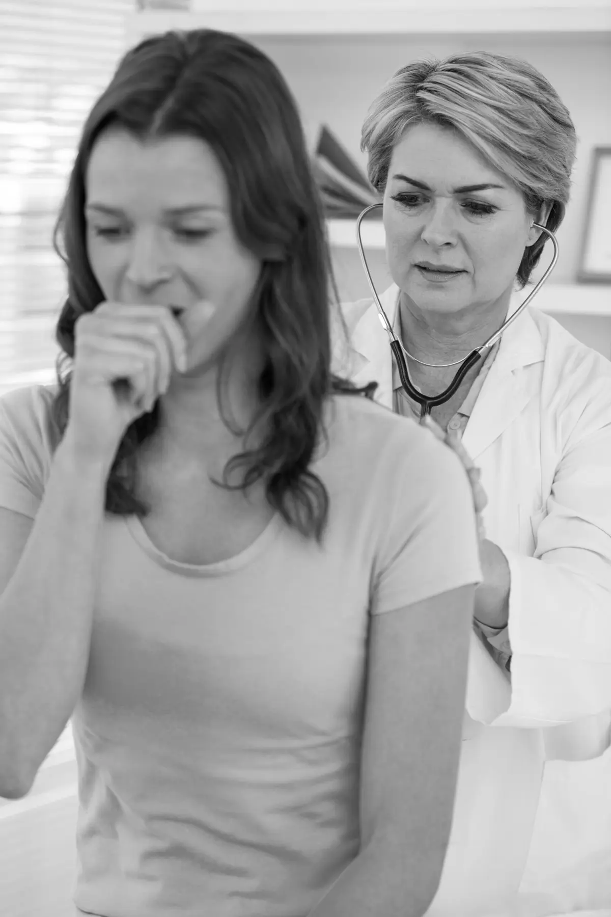 A doctor listening to a patient's lungs