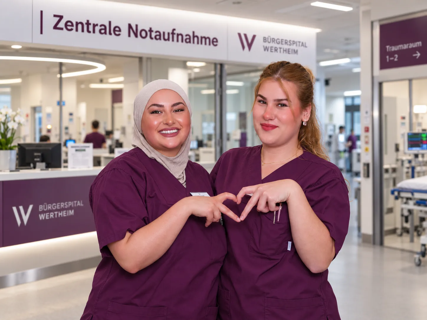 Two nurses of the Bürgerspital Wertheim form a heart with their hands in front of the central emergency department